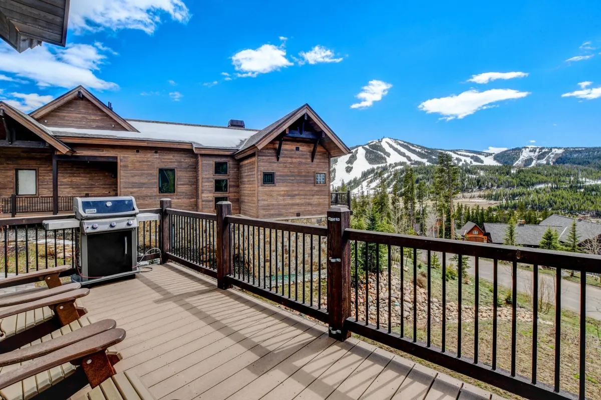 An expansive deck featuring comfortable seating, a barbecue grill, and unobstructed views of the surrounding mountains. The outdoor area is designed for both relaxation and entertaining, making it ideal for enjoying meals or sunsets with friends and family.
